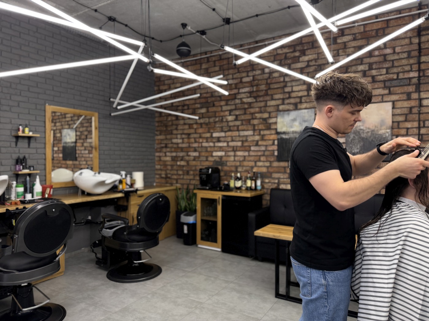 Wnętrze barbershopu OLD BRAND z ciepłej cegły i drewna przy ul. Wiejskiej w Białymstoku