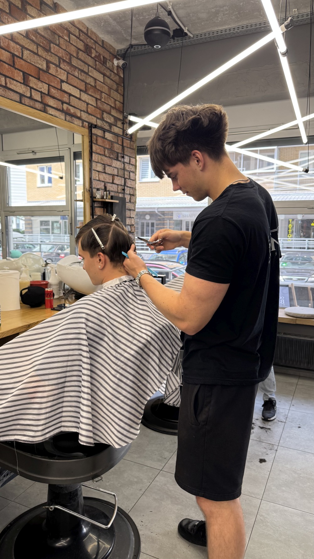 Barber OLD BRAND modeluje fryzurę klienta podczas wizyty w barbershopie w Białymstoku